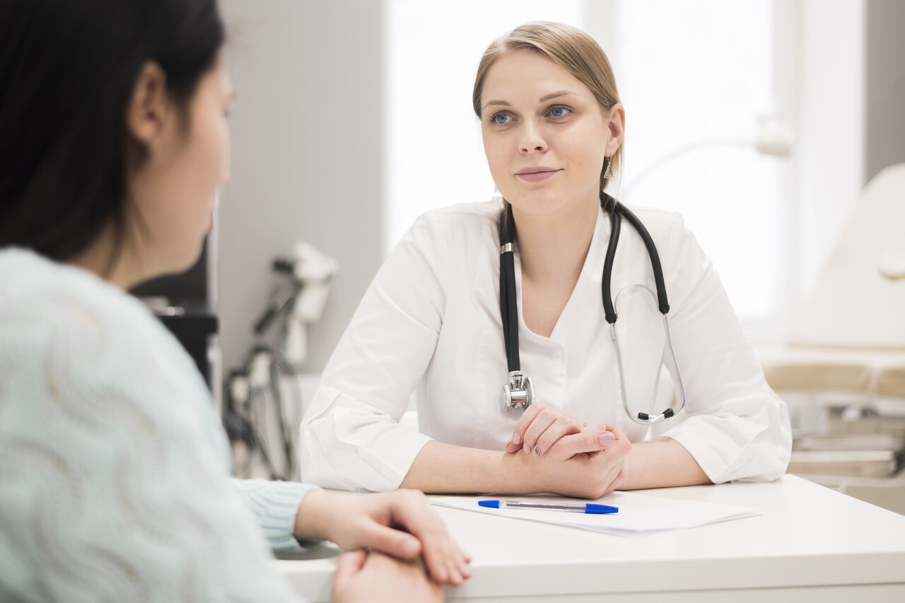 a doctor is talking to her patient in her office room, she is graduated from medical school after using ucat score to applying to the university.