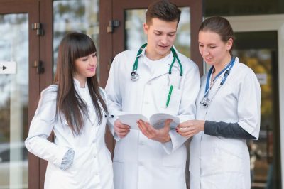 A cheerful group of Medicine MBBS/BSc students from Imperial College are reading papers.